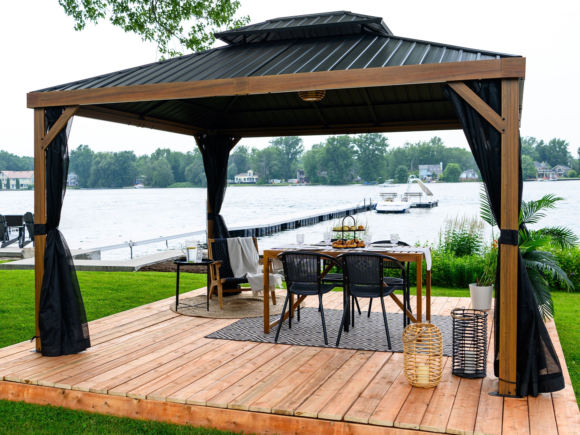 Wooden gazebo with outdoor furniture by a waterfront