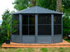 The penguin gazebo Florence Solarium 12x12 in slate pictured on a wooden patio next to the water front