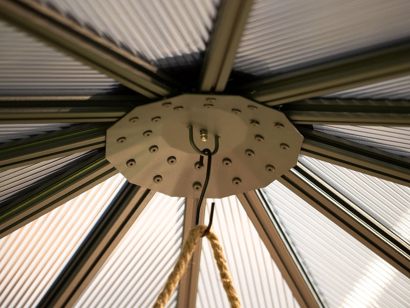 Ceiling light fixture with ribbed design and rope hanging against a textured ceiling